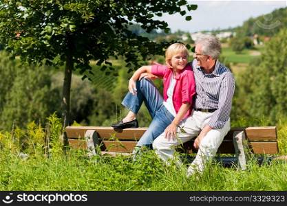 Visibly happy mature or senior couple outdoors arm in arm deeply in love