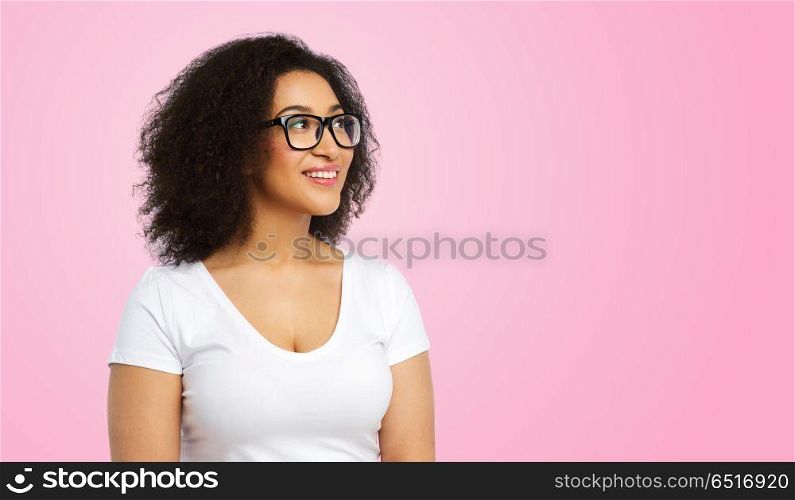 vision, body positive and people concept - happy african american woman in white t-shirt and glasses over pink background. african american woman in glasses and t-shirt. african american woman in glasses and t-shirt
