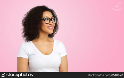 vision, body positive and people concept - happy african american woman in white t-shirt and glasses over pink background. african american woman in glasses and t-shirt. african american woman in glasses and t-shirt