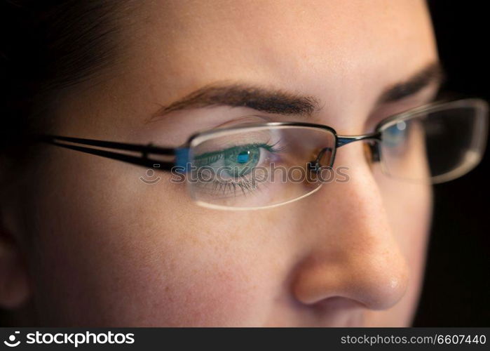 vision, business and education concept - close up of woman eyes in glasses looking at computer screen. close up of woman in glasses looking at screen