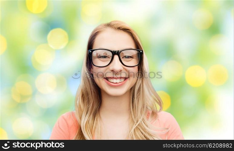 vision, education and people concept - happy smiling young woman or teenage girl eyeglasses over summer green lights background