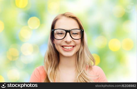 vision, education and people concept - happy smiling young woman or teenage girl eyeglasses over summer green lights background