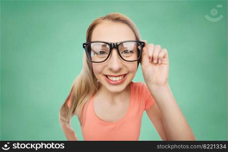vision, education and people concept - happy smiling young woman or teenage girl eyeglasses over green school chalk board background