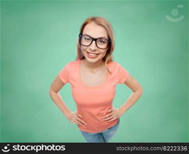 vision, education and people concept - happy smiling young woman or teenage girl eyeglasses over green school chalk board background