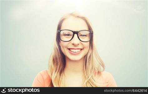 vision, education and people concept - happy smiling young woman or teenage girl eyeglasses over gray background. happy young woman or teenage girl in eyeglasses