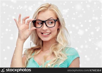 vision, education and people concept - happy smiling young woman or teenage girl glasses over snow