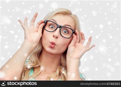 vision, education and people concept - happy young woman or teenage girl glasses making funny fish face over snow
