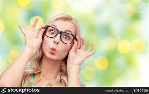 vision, education and people concept - happy young woman or teenage girl glasses making funny fish face over summer green lights background