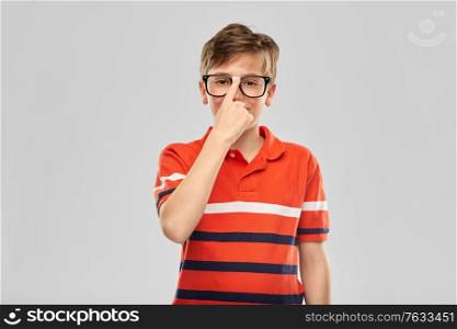 vision, education and school concept - portrait of happy smiling boy in eyeglasses and red polo t-shirt over grey background. portrait of happy smiling boy in eyeglasses
