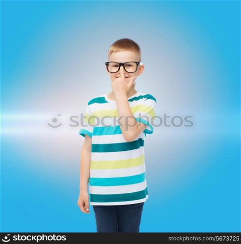 vision, education and school concept - smiling little boy in eyeglasses over blue background with laser light