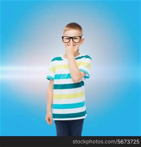 vision, education and school concept - smiling little boy in eyeglasses over blue background with laser light