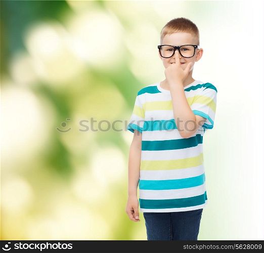 vision, education, ecology and school concept - smiling little boy in eyeglasses over green background