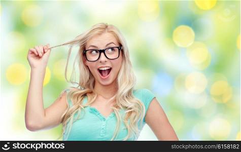 vision, education, expression, summer and people concept - happy smiling young woman or teenage girl glasses over green lights background
