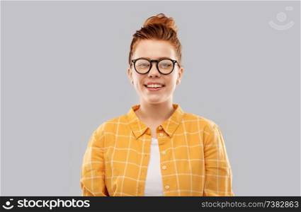 vision, education people concept - smiling red haired teenage student girl in glasses and checkered shirt over grey background. smiling red haired teenage student girl in glasses
