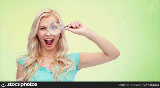vision, exploration, investigation, education and people concept - happy smiling young woman or teenage girl looking through magnifying glass over green natural background