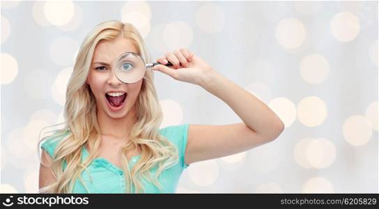 vision, exploration, investigation, education and people concept - happy smiling young woman or teenage girl looking through magnifying glass over holidays lights background