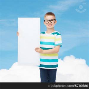 vision, health, advertisement and childhood concept - smiling little boy in eyeglasses with blank board over blue cloudy sky background