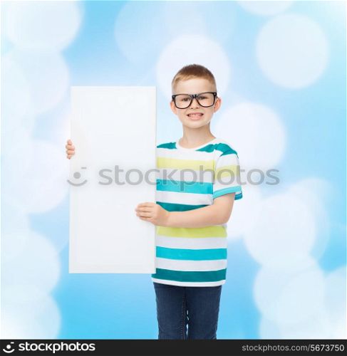 vision, health, advertisement and people concept - smiling little boy in eyeglasses with white blank board over blue background