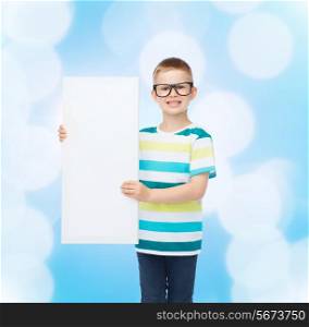 vision, health, advertisement and people concept - smiling little boy in eyeglasses with white blank board over blue background