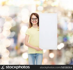 vision, health, advertisement and people concept - smiling little girl wearing eyeglasses with white blank board