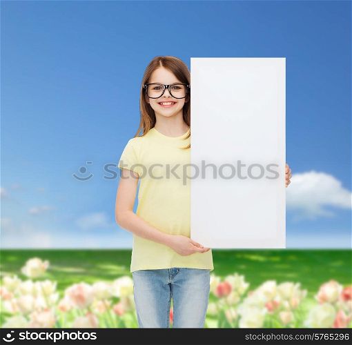 vision, health, advertisement and people concept - smiling little girl wearing eyeglasses with white blank board