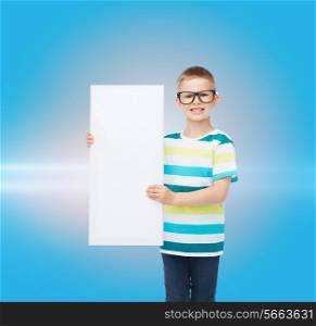 vision, health, advertisement, childhood and people concept - smiling little boy in eyeglasses with white blank board over blue background with laser light