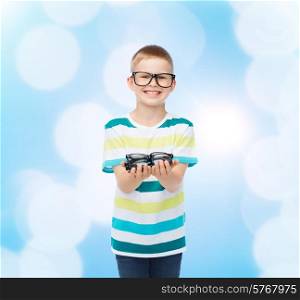 vision, health and people concept - smiling little boy in eyeglasses holding spectacles over blue background