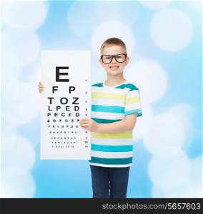 vision, health, childhood, ophthalmology and people concept - smiling little boy in eyeglasses with with eye chart over blue background