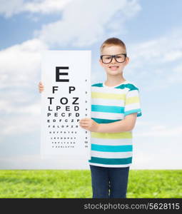 vision, health, ophthalmology, childhood and people concept - smiling little boy wearing eyeglasses with eye chart over natural background