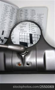 Vision magnifying glass used to view crossword puzzle.