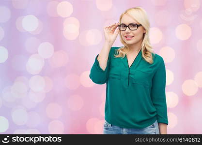 vision, optics, education and people concept - smiling young woman with eyeglasses over blue background