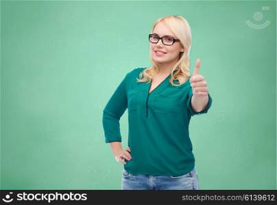 vision, optics, education, gesture and people concept - smiling young woman with eyeglasses showing thumbs up over green school chalk board background