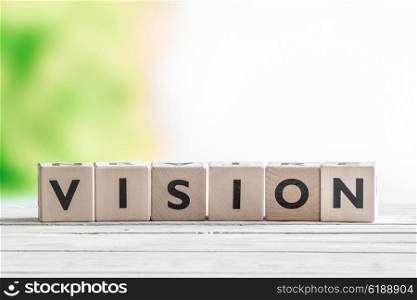 Vision sign made of wooden cubes on a desk