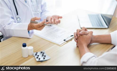 Visiting a doctor concept A physician diagnosing his patient&rsquo;s symptom and giving description of the patient&rsquo;s condition