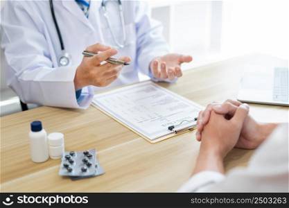 Visiting a doctor concept A physician diagnosing his patient&rsquo;s symptom and giving description of the patient&rsquo;s condition