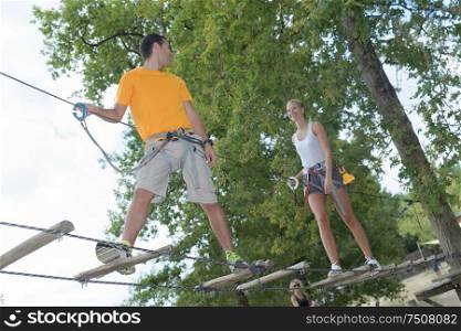 visitors in adventure park clambering with ropes