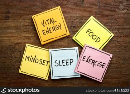 vital energy concept on sticky notes. vital energy concept - food, exercise, mindset and sleep handwritten on colorful sticky notes against rustic wood