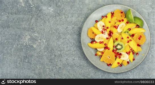 Vitamin salad of mango, citrus, banana and berries. Copy space for text. Fruit salad of citrus and berries.