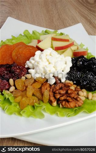 Vitamin salad with nuts, apples, dried fruit and cottage cheese in lettuce leaves