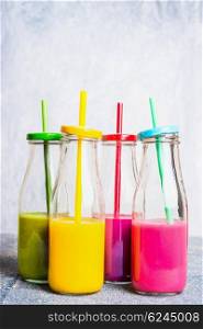 Vitamin smoothie in bottles with straws on light background. Superfoods and healthy lifestyle or detox diet food concept.