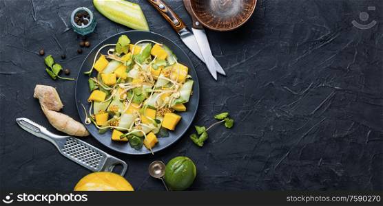 Vitamin spring salad with mango, cucumber, sprouts and mustard.Copy space.Vegetarian dish,healthy food. Vegetable fruit salad with sprouts