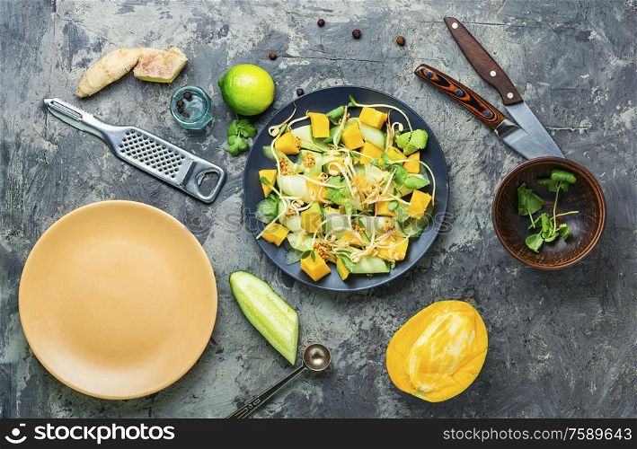 Vitamin spring salad with mango, cucumber, sprouts and mustard.. Vegetable fruit salad with sprouts