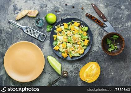 Vitamin spring salad with mango, cucumber, sprouts and mustard.. Vegetable fruit salad with sprouts