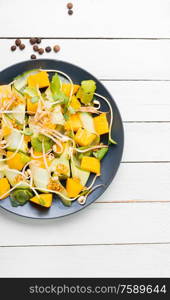Vitamin spring salad with mango, cucumber, sprouts and mustard.Vegetarian dish,healthy food. Vegetable fruit salad with sprouts