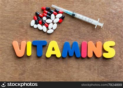 Vitamins colorful word in the wooden background