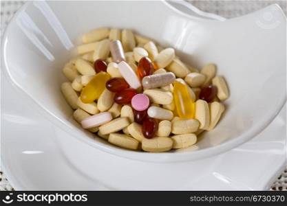 Vitamins in bowl of tablets for breakfast in kitchen