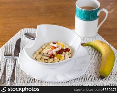 Vitamins in bowl of tablets for breakfast in kitchen