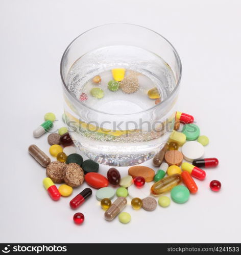 vitamins, tablets and pills and glass of water