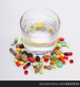 vitamins, tablets and pills and glass of water