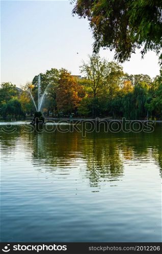 Vivid green landscape near the lake in Cismigiu Garden (Gradina Cismigiu), a public park in the city center of Bucharest